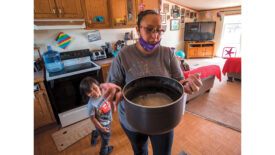 woman in a kitchen with a pot of water