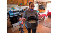 woman in a kitchen with a pot of water